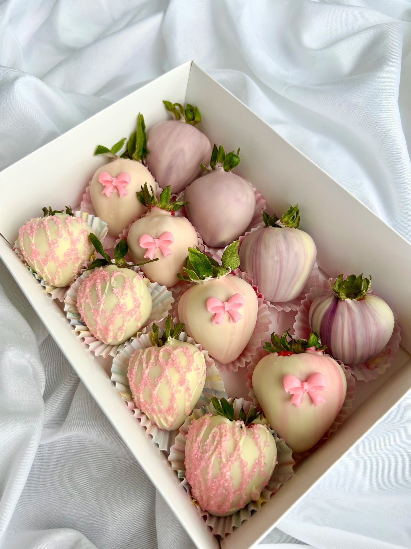 pink and purple chocolate dipped strawberries in white box on the white background