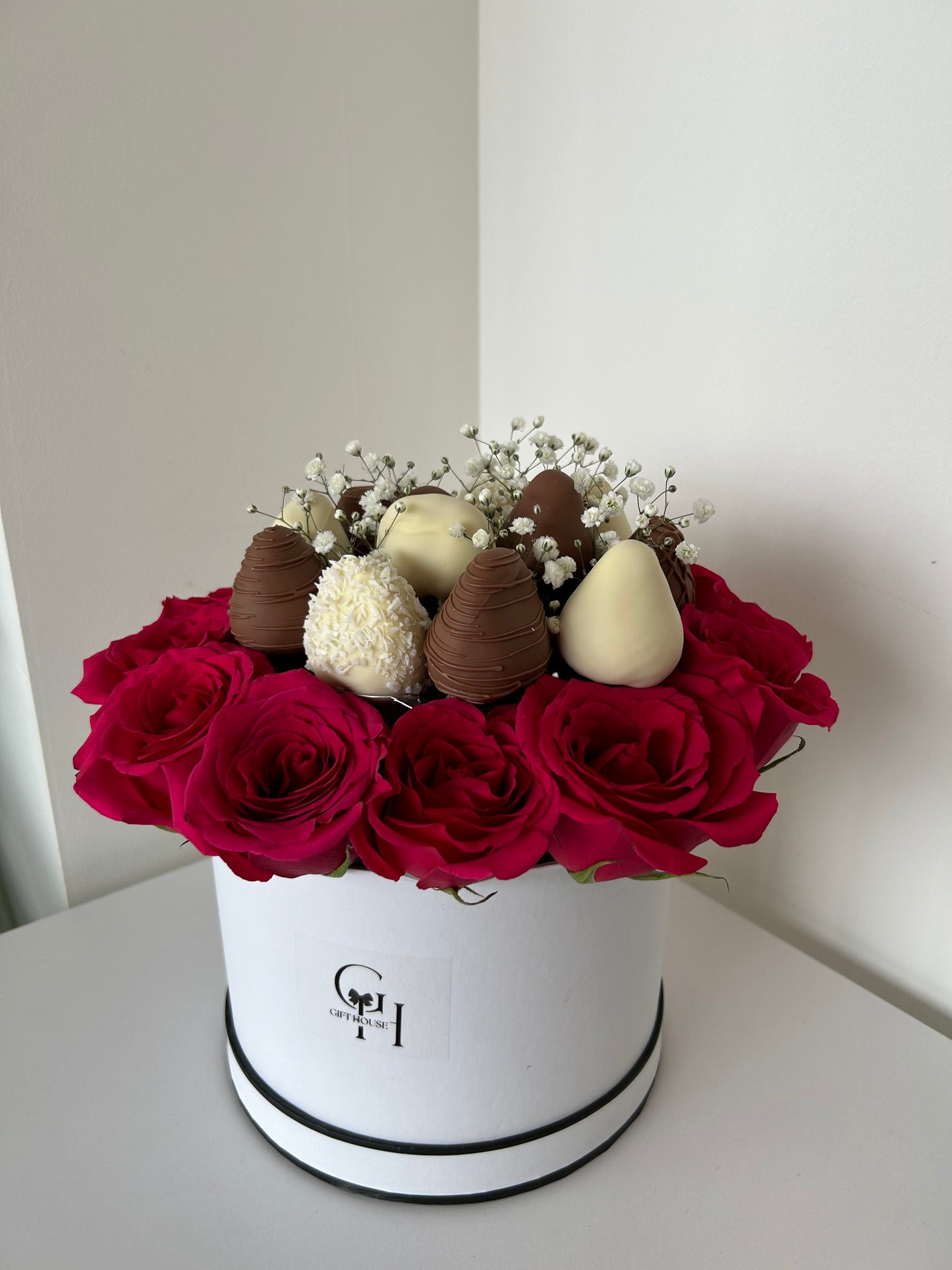 chocolate covered strawberries and red roses in white floral box 