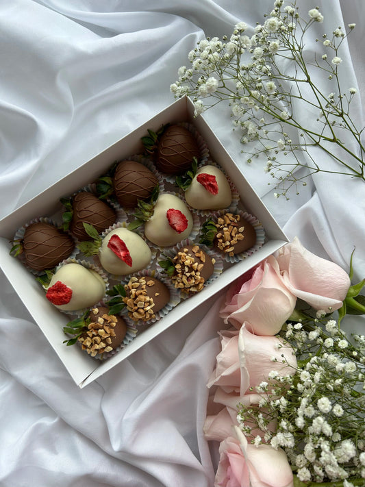 12 chocolate covered strawberries in a white box with roses on background 