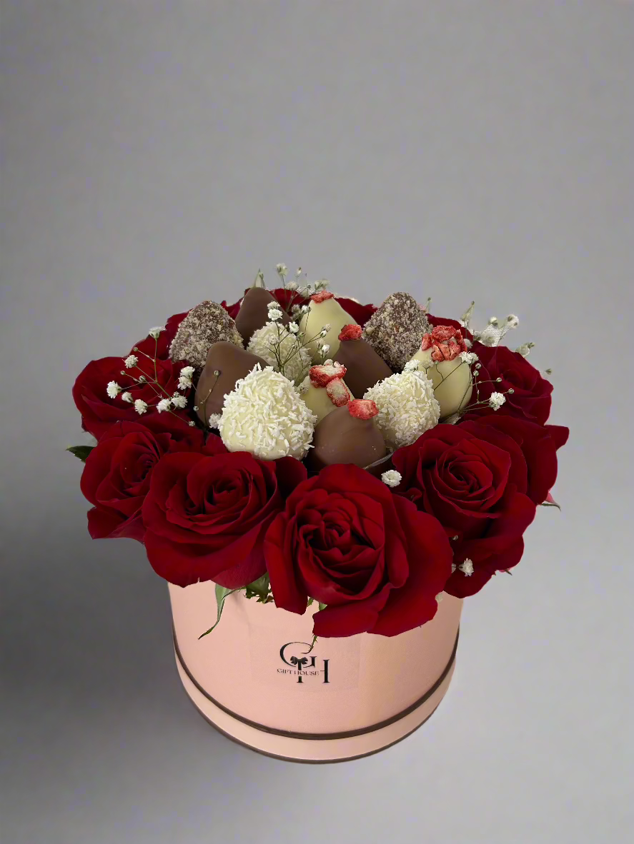 close up chocolate covered strawberries and red roses in pink floral box 