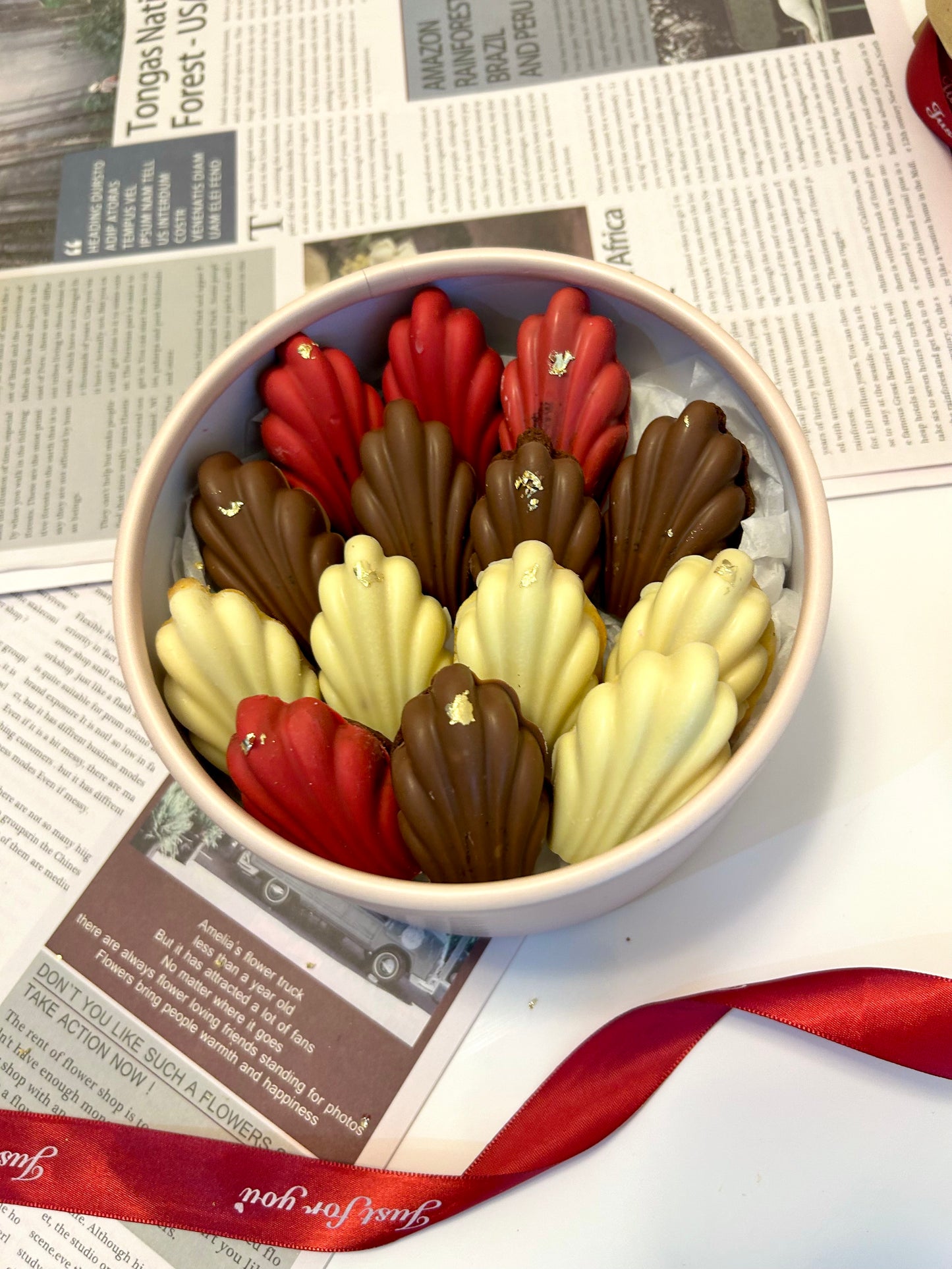Madeleines in round box with ribbon on background 
