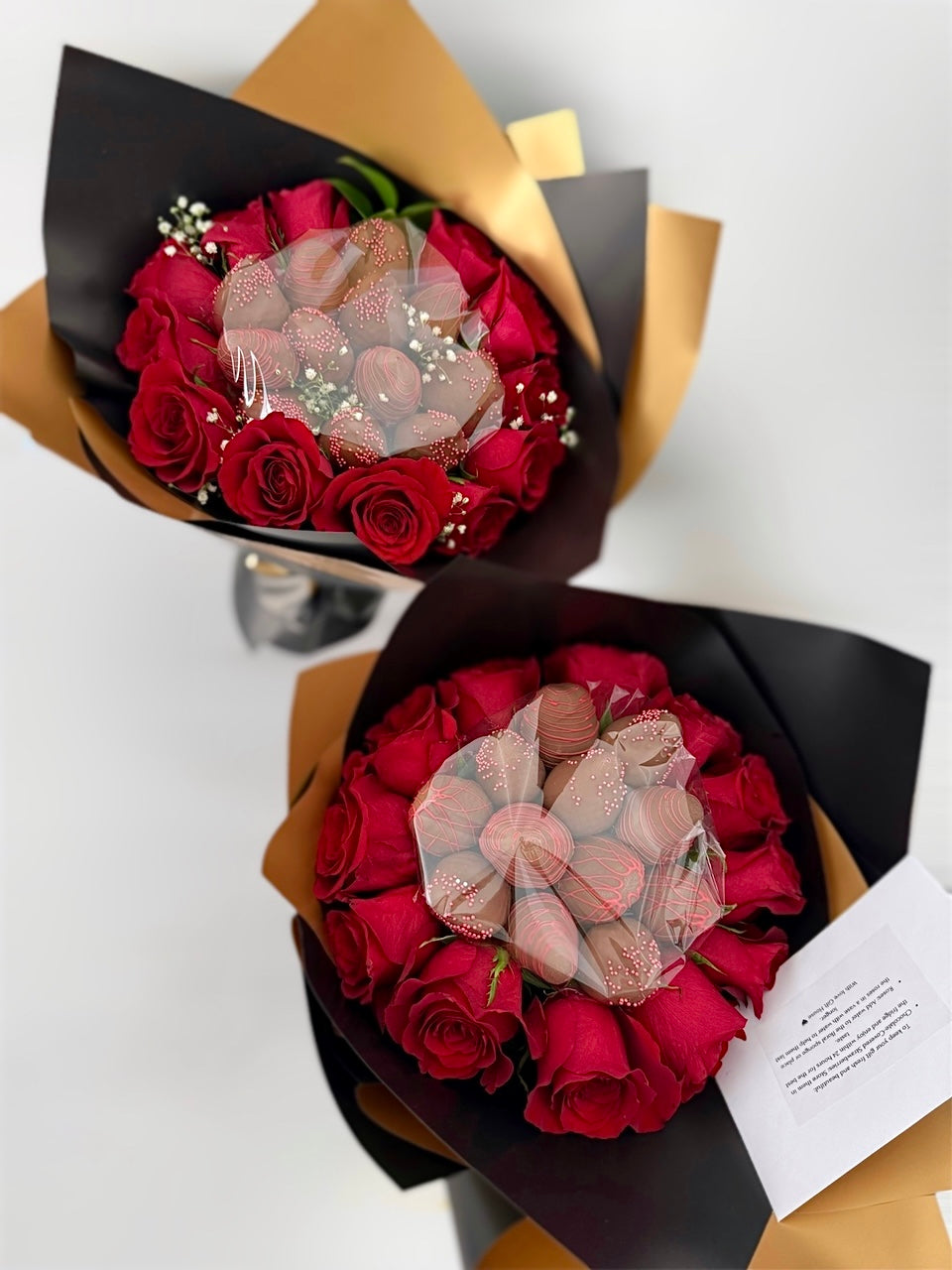 two bouquets with red roses and chocolate dipped strawberries on white background