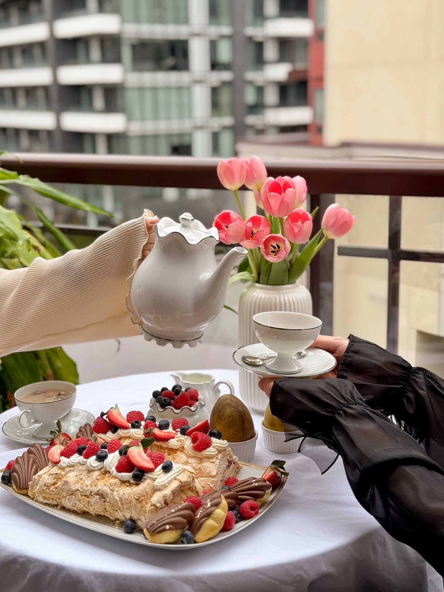 Two-piece meringue roulade set on elegant serving tray with fresh fruit